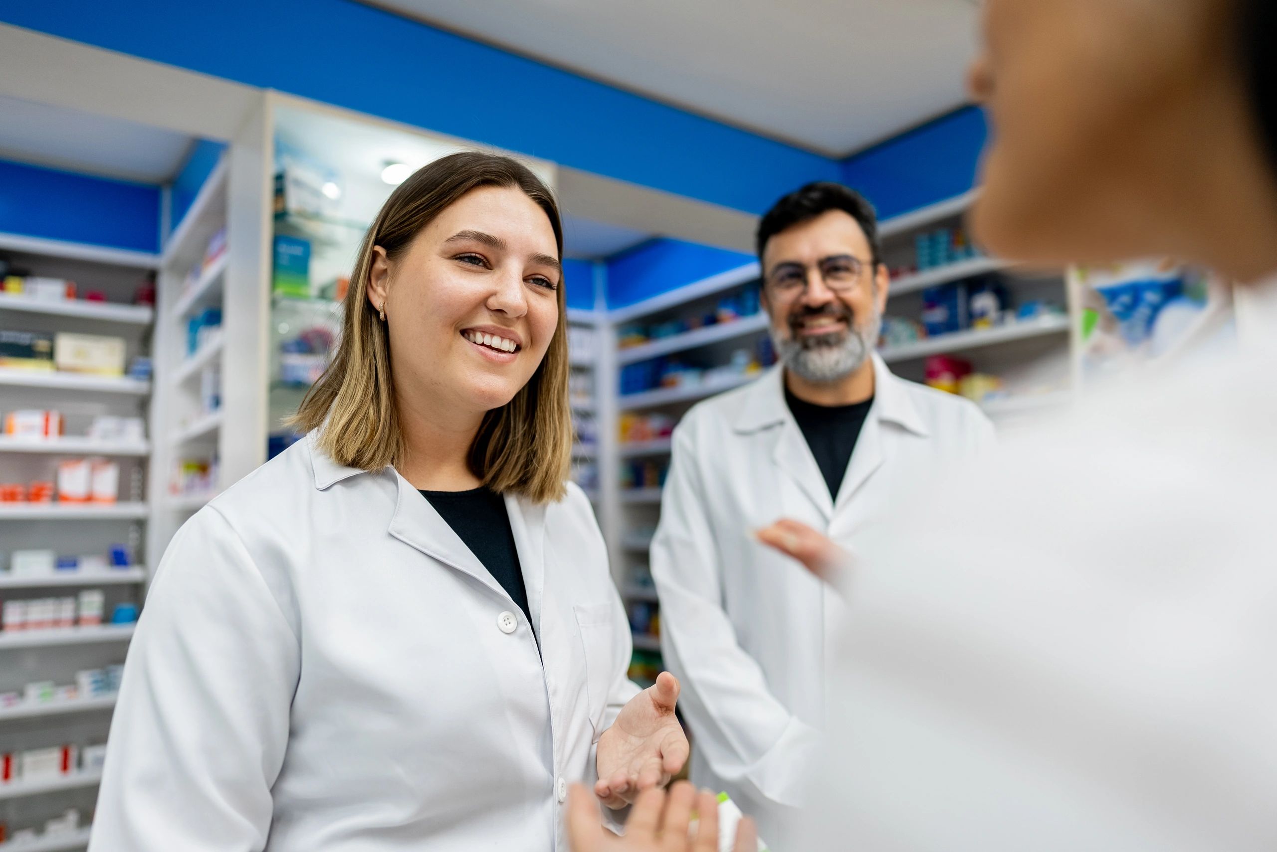 Pharmacy staff supporting a customer at the counter
